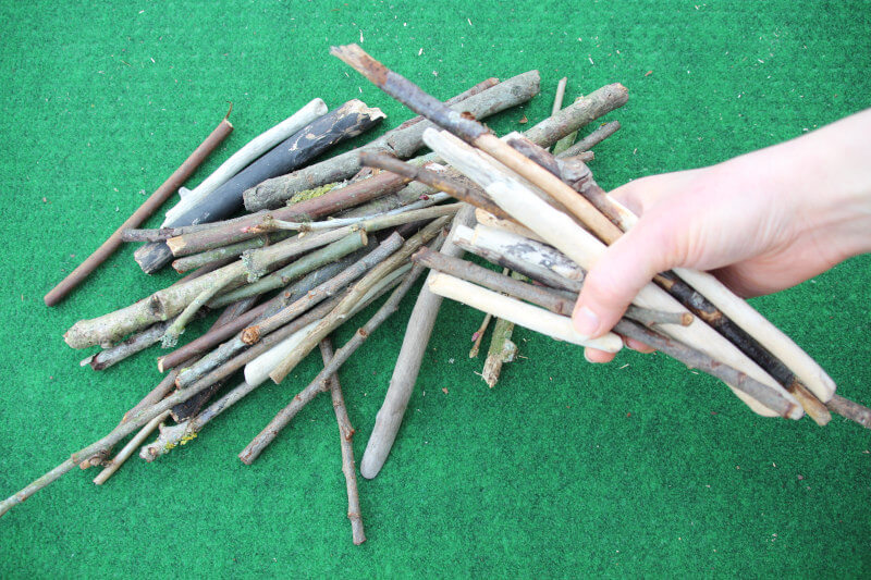 handful of outdoor maths sticks for division by four activity